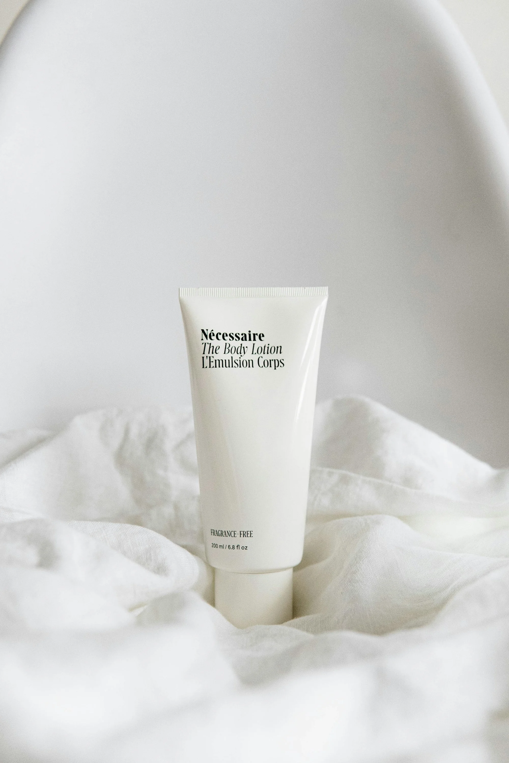 Minimalist skincare bottle resting on soft linen